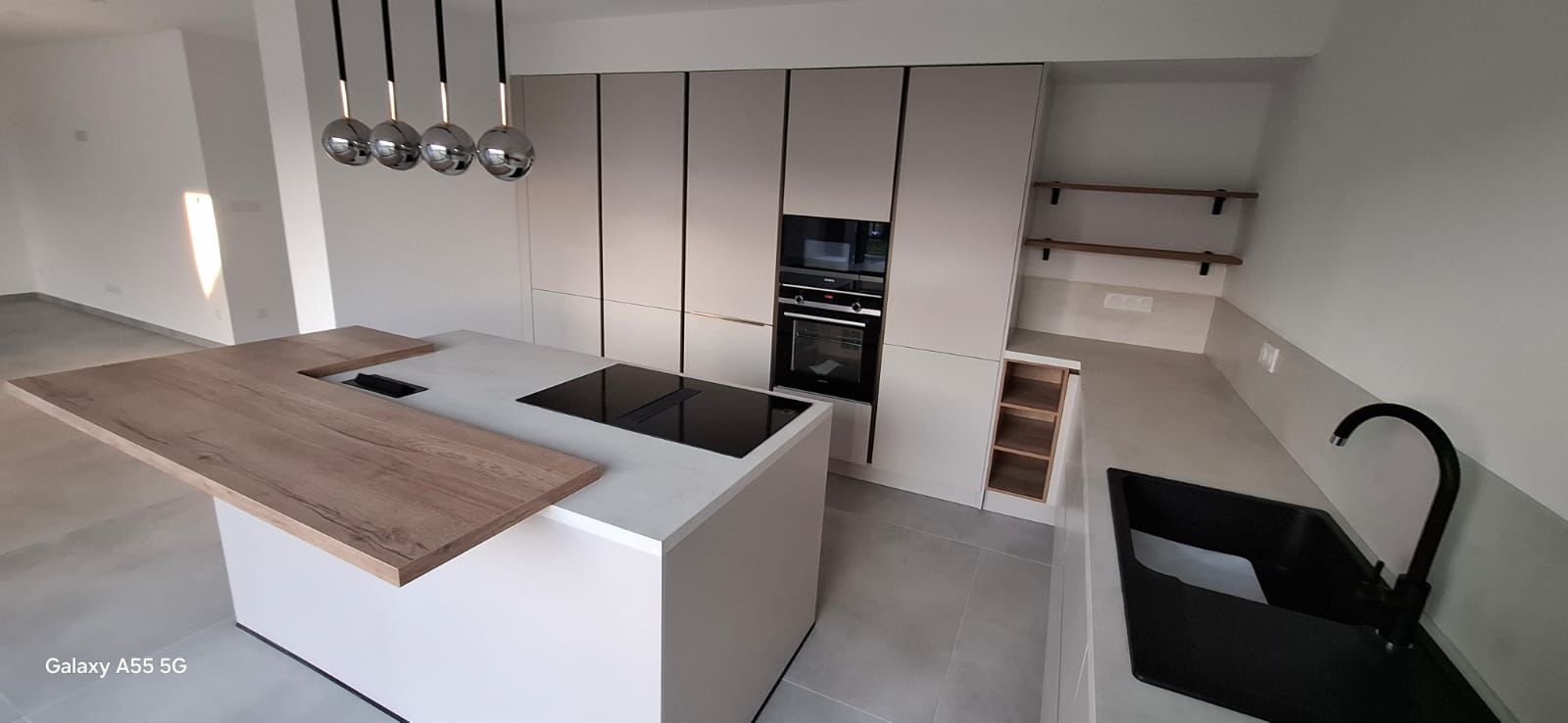 Cuisine claire avec îlot et plan de travail en bois réalisée par le partenaire